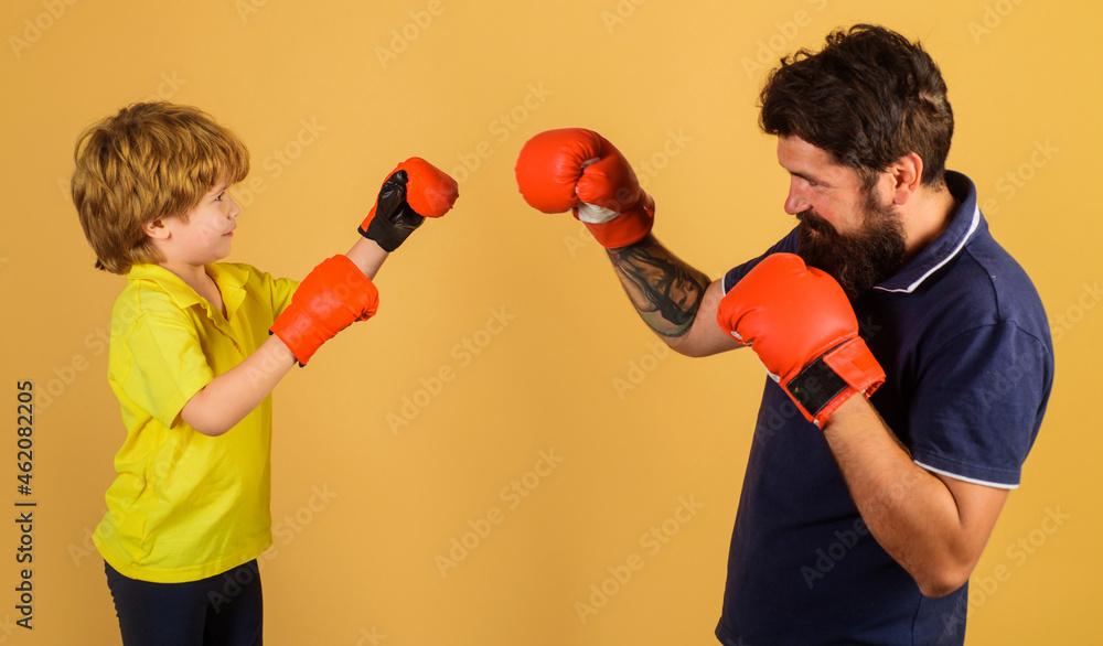 Kid in boxing gloves training with coach. Punching knockout. Childhood activity. Trainer teaching child how to hit punches. Kid in boxing gloves training with coach. Punching knockout. Childhood activity. Trainer teaching child how to hit punches.