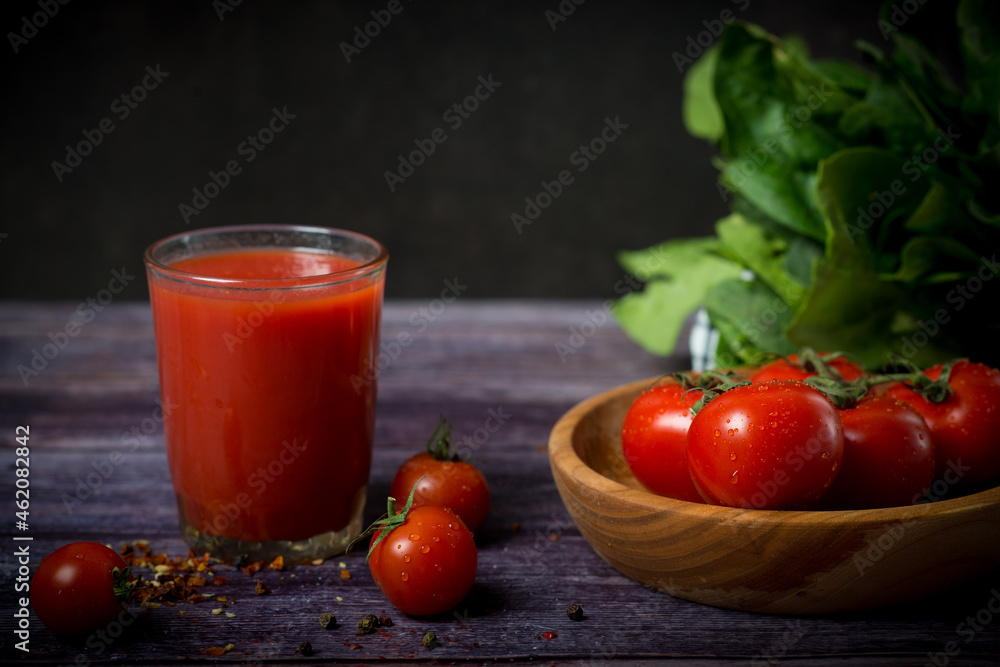 cherry tomatoes and tomato juice on a black background cherry tomatoes and tomato juice on a black background