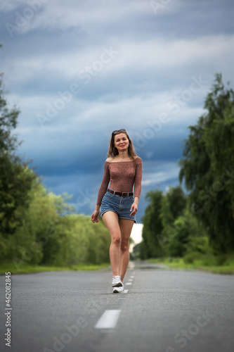 Young woman walking alone in the middle of the road. 
