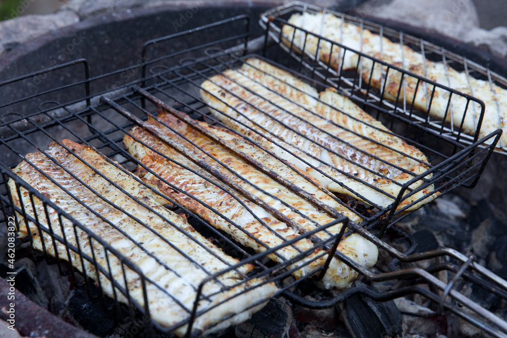 The process of cooking cod fillets on the grill