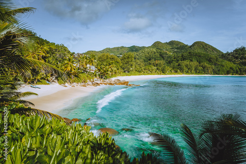 Mahe Island, Seychelles. Holiday vocation on the beautiful exotic Anse intendance tropical beach. Ocean wave rolling towards sandy beach with coconut palm trees