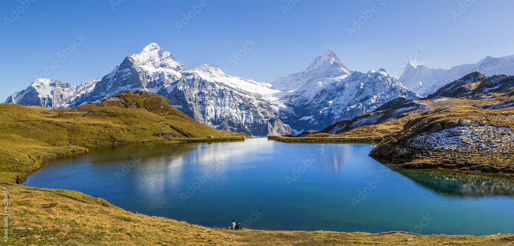 Panorama of Bachalpsee at the First peak over Grindelwald with the snow-covered Alps summit Wetterhorn, Schreckhorn, Eiger at the background