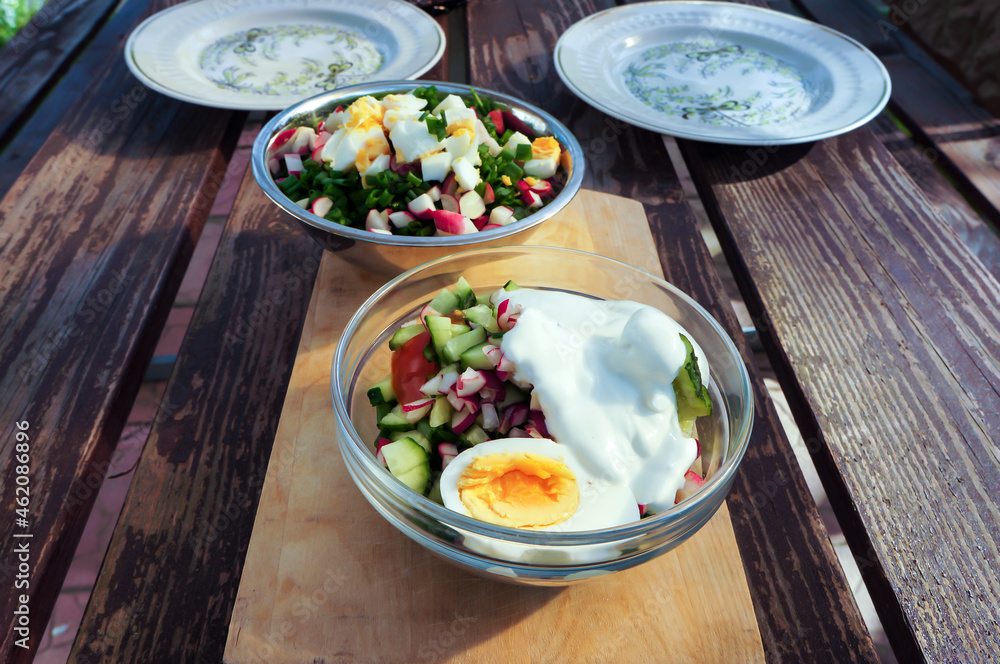 Fresh vegetables salad with eggs in bowls on wooden table. Fresh vegetables salad with eggs in bowls on wooden table.