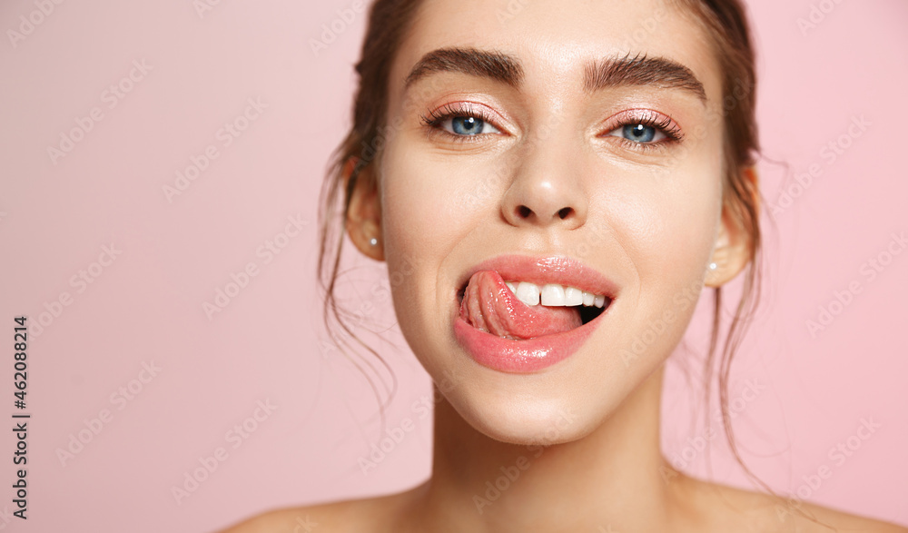 Close up of happy young woman with fresh glowing skin tone, showing beautiful white smile and grinning carefree, happy about valentines day, standing on pink background Close up of happy young woman with fresh glowing skin tone, showing beautiful white smile and grinning carefree, happy about valentines day, standing on pink background