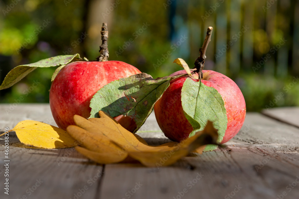Red apples with leaves on a wooden table