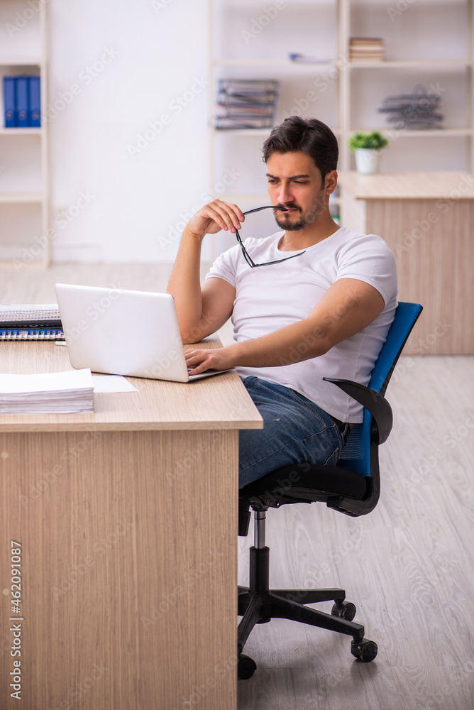 Young male student employee at workplace Young male student employee at workplace