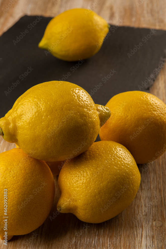 Lemons on slate plate and wooden background Lemons on slate plate and wooden background