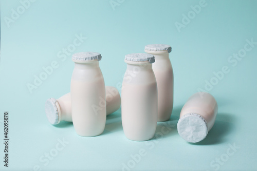 Bottles with probiotics and prebiotics dairy drink on light blue background. Bio yogurt with useful microorganisms. Production with biologically active additives. Fermentation and diet healthy food.
