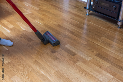 Close up view of vacuuming of parquet floor moment. Sweden. 