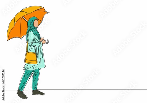 Single continuous line drawing of young cute muslimah with arabic veil carrying umbrella and pocket bag. Beautiful Asian woman in trendy hijab fashion concept one line draw design vector illustration