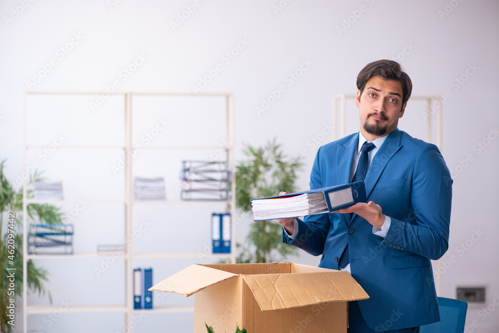 Young male employee in business relocation concept Young male employee in business relocation concept