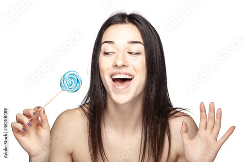 studio portrait of a beautiful brunette girl with lollipop against white backgroung.