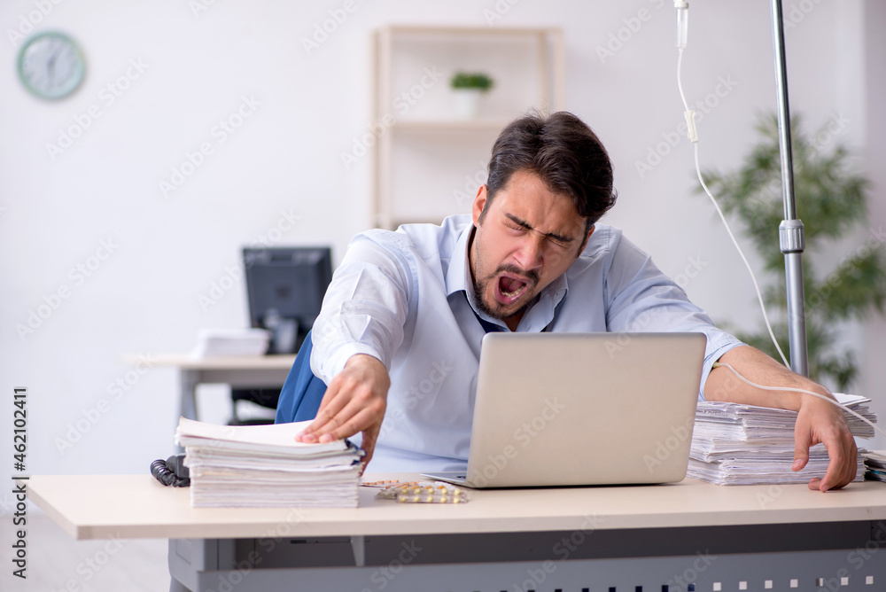 Young male employee suffering at workplace Young male employee suffering at workplace