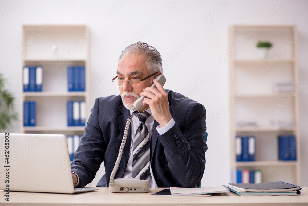 Old male employee working in the office Old male employee working in the office