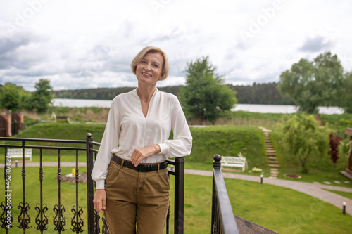 Pleased elegant lady posing against a picturesque landscape