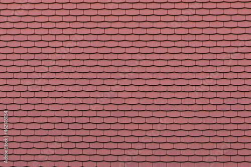 Red tiles on a roof texture. Background structure for the use as backdrop. Full frame pattern of multiple items. A surface full of repeating bricks.