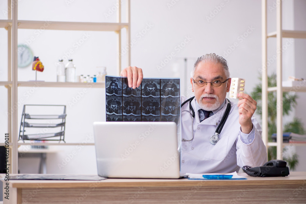 Old male doctor radiologist working in the clinic Old male doctor radiologist working in the clinic
