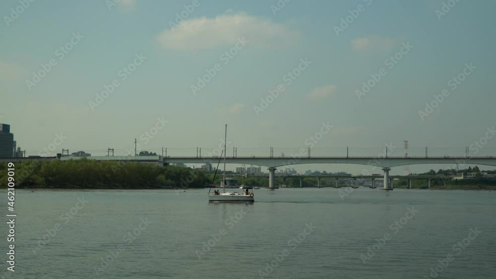 Korean Couple Silhouette Sitting on Bow of Small Yacht During Private Cruise on Hangang river near Seoul Marina Club. Dangsan Railroad Bridge, Yanghwa Bridge on Background South Korea, blue sky Korean Couple Silhouette Sitting on Bow of Small Yacht During Private Cruise on Hangang river near Seoul Marina Club. Dangsan Railroad Bridge, Yanghwa Bridge on Background South Korea, blue sky