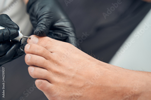 Beautician hands doing hardware pedicure for male client