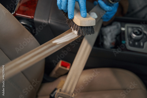 Photo of manual cleaning car interior during detailing