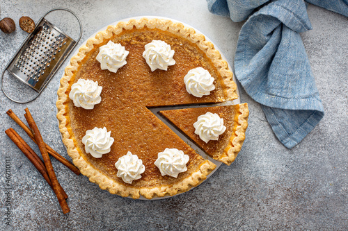Traditional pumpkin pie with whipped cream and cinnamon photo