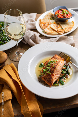 Roasted salmon served on top of greens photo