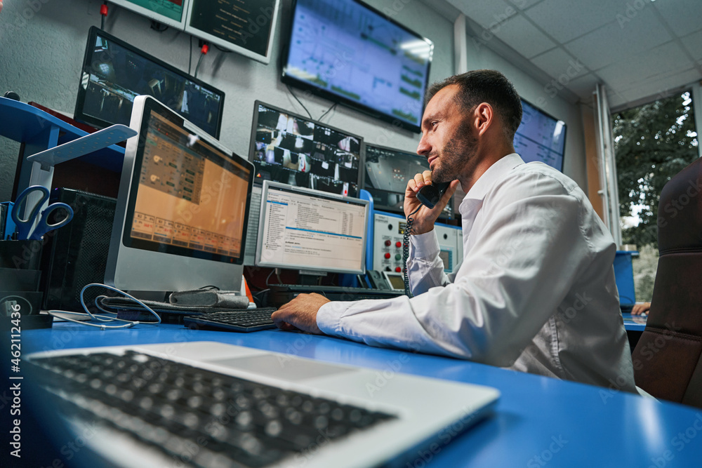 Server technician answering phone call from control room