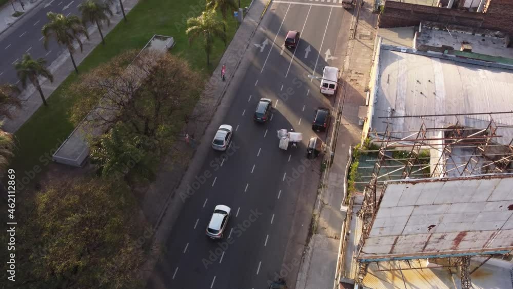 Cartonero pulling cart on busy road at Buenos Aires city, Argentine. Aerial drone view Cartonero pulling cart on busy road at Buenos Aires city, Argentine. Aerial drone view