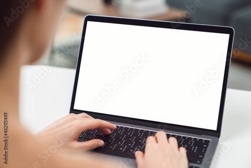 Woman hand using laptop and sitting on the table in the house, mock-up of a blank screen for the application.