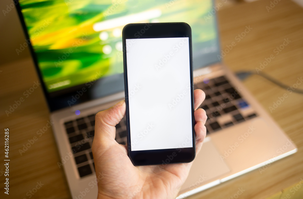 Hand holding smartphone with blank screen. Using smartphone indoors. Hand holding smartphone with blank screen. Using smartphone indoors.
