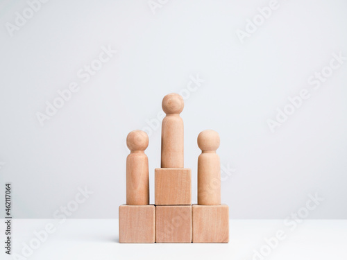 Business competition winner. The wooden figure standing on the winner podium, wood cube block on white background with copy space, minimal style. Goals, success, and leadership concept.