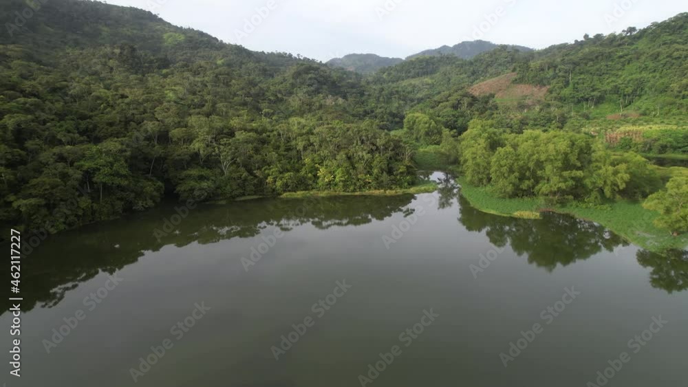 Ascending Cinematic Aerial view over green lagoon and reflection of forest jungle trees. summer day in Honduras, Central America. rainforest from above at Sunris Ascending Cinematic Aerial view over green lagoon and reflection of forest jungle trees. summer day in Honduras, Central America. rainforest from above at Sunris