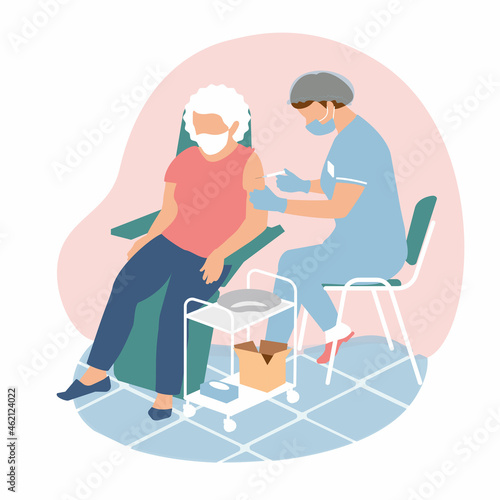 A masked nurse in a medical suit, gloves, mask gives an injection of a vaccination for immunization coronavirus to a old woman. Protection the spread of covid 19. The use of vaccines for elderly 
