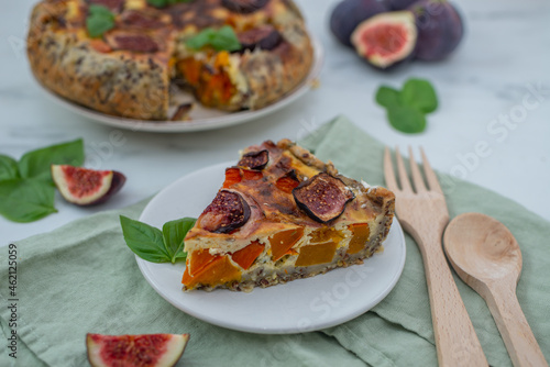 Home made autumn quiche with pumpkin and figs on a table