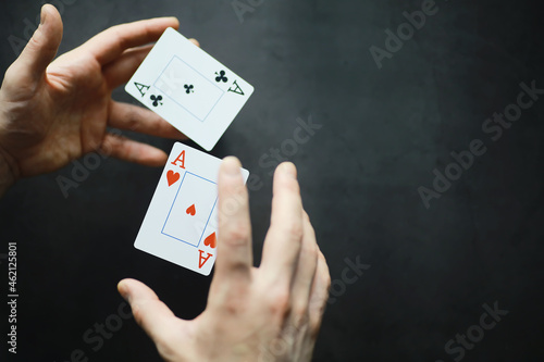 The concept of card tricks and presentations. The concept of a sharpie in games. Flying cards in the air. A magician raises cards with the power of thought.