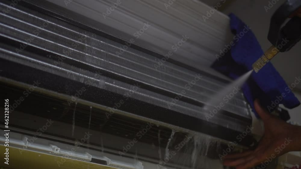 hand of technician service cleaning air conditioner by water spray hand of technician service cleaning air conditioner by water spray