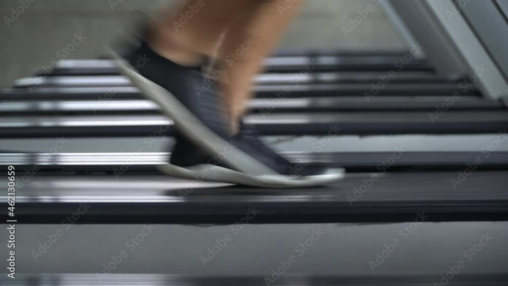 Low angle of leg and shoes man running on treadmill in fitness gym at sport club . motivation and workout . closeup foot and sneaker of sport guy Exercise on running Machine. cardio training Low angle of leg and shoes man running on treadmill in fitness gym at sport club . motivation and workout . closeup foot and sneaker of sport guy Exercise on running Machine. cardio training