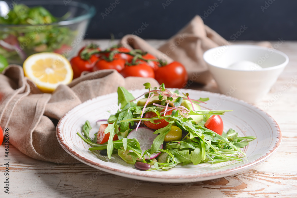 Plate with delicious salad on light wooden background Plate with delicious salad on light wooden background