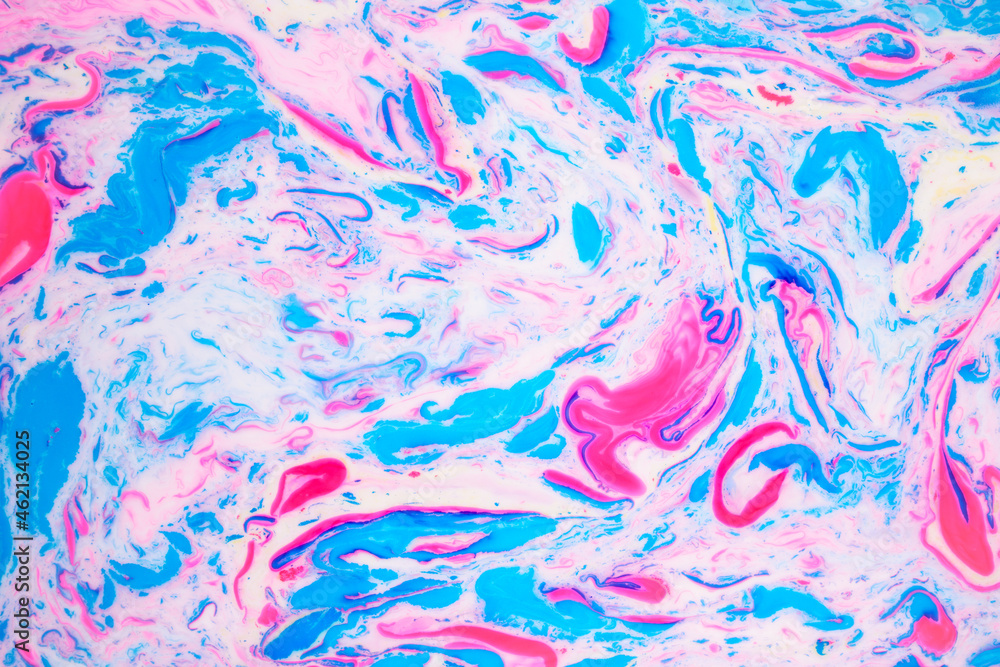 Fototapeta premium Variegated colored background, paint particles on white. Dye stains on the surface of the liquid. Abstract background.