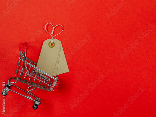 Tags on red background with shopping cart. Sale, shopping, discount.