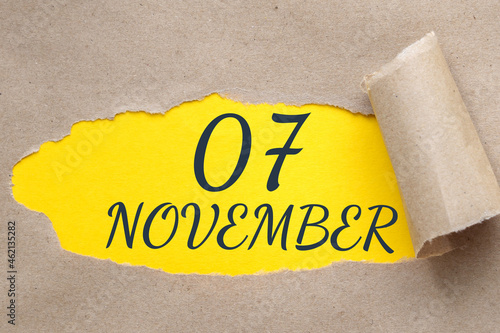 november 07. 07th day of the month, calendar date.Hole in paper with edges torn off. Yellow background is visible through ragged hole.Autumn month, day of the year concept photo