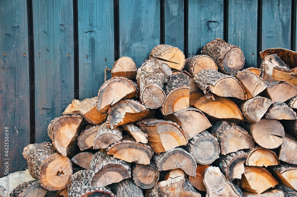 Pile of firewood against wooden background Pile of firewood against wooden background