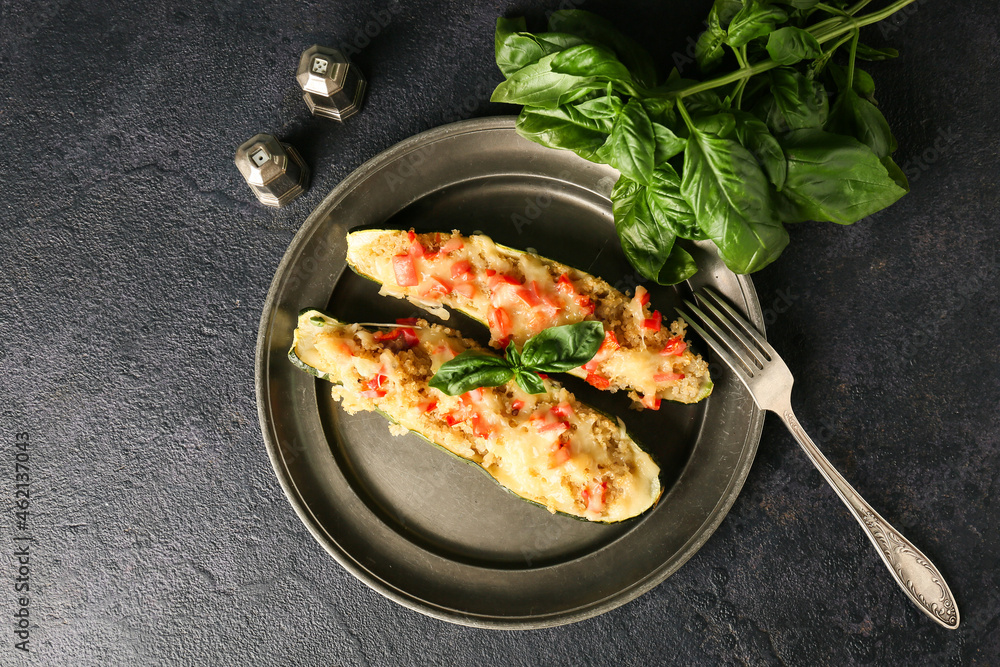 Plate with quinoa stuffed zucchini boats on dark background Plate with quinoa stuffed zucchini boats on dark background