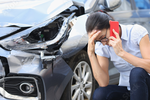 Obraz na płótnie Upset woman talking on phone against background of broken car w salonie