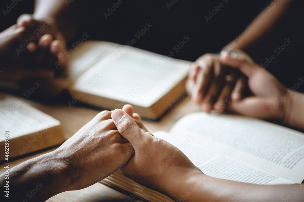 Christian group of people holding hands praying worship to believe and