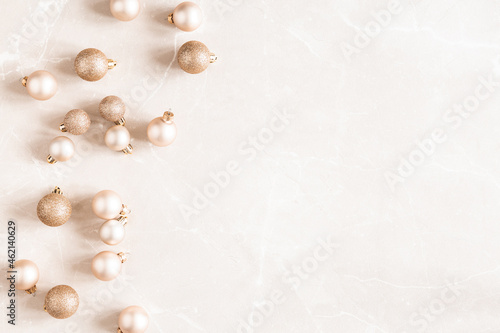 Christmas composition. Golden decorations on marble beige background. Christmas, winter, new year concept. Flat lay, top view, copy space © Flaffy