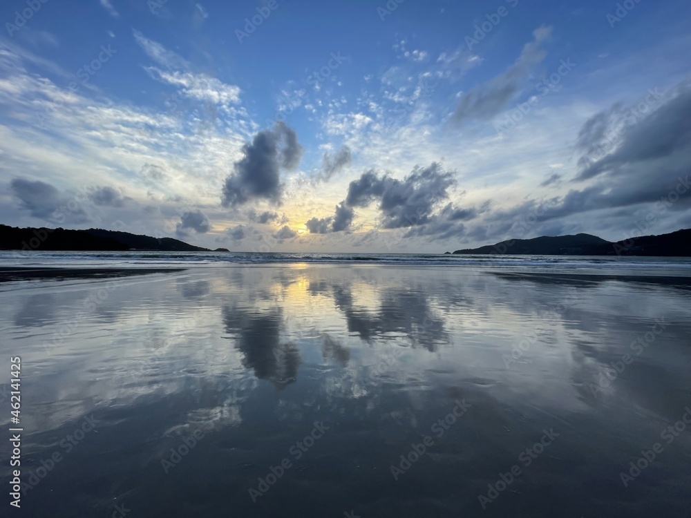 Amazing sunset over the sea. Perfect panorama. Seascape. Very beautiful clouds on the sky. Reflection on the surface of water. Abstract pattern of clouds, colored by sun downing glow. Idyllic picture.