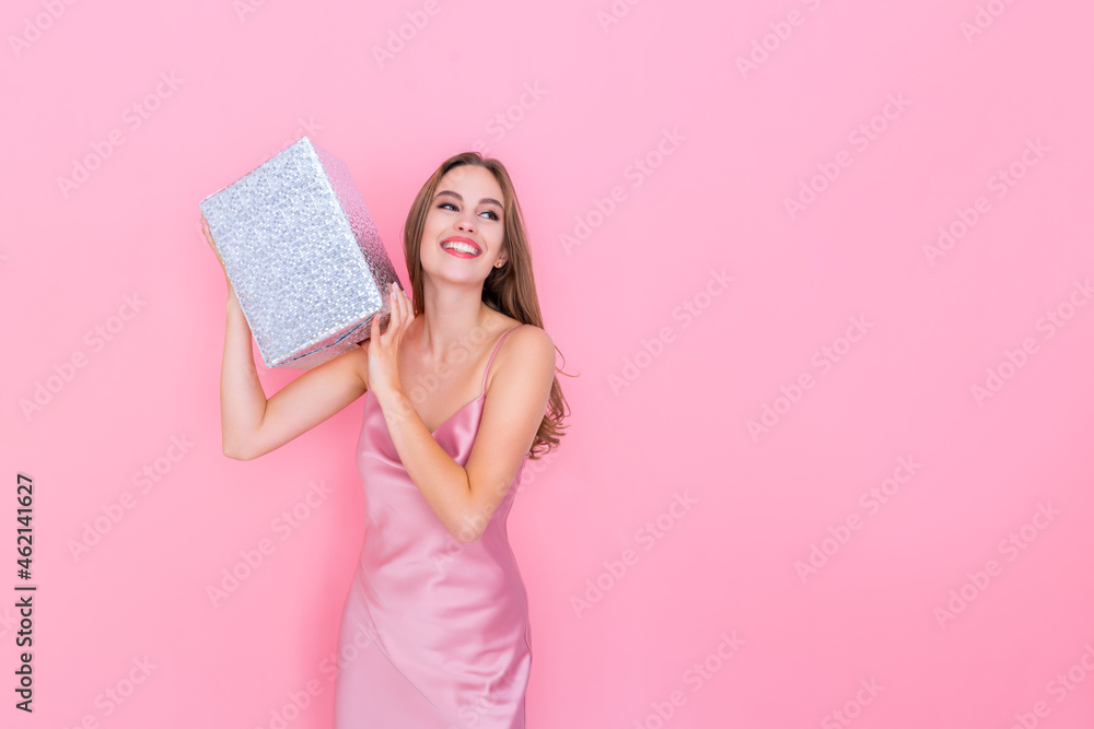 Image of happy girl shaking box with gift wonder what inside wrapped box stands on pink background Image of happy girl shaking box with gift wonder what inside wrapped box stands on pink background