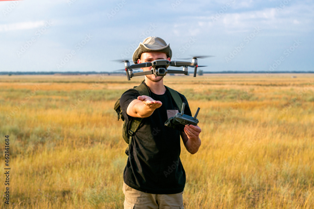 Fototapeta premium a tourist guy launches a quadcopter with his hand in front of him
