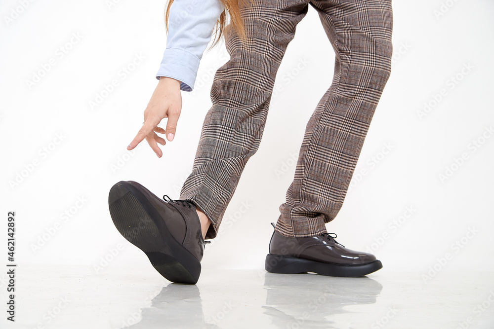 Brown female or male patent leather shoes on legs of woman. Shooting for a catalog or an online store. A pair of shoes Brown female or male patent leather shoes on legs of woman. Shooting for a catalog or an online store. A pair of shoes